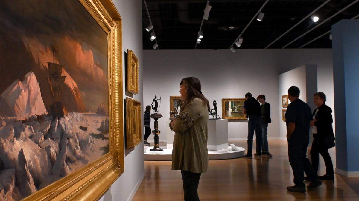 Visitors at the Mint Museum Uptown’s exhibition, “American Made: Paintings and Sculpture from the Demell Jacobsen Collection.” The exhibition is a survey of two centuries of American art and the distinctive styles of American artists.