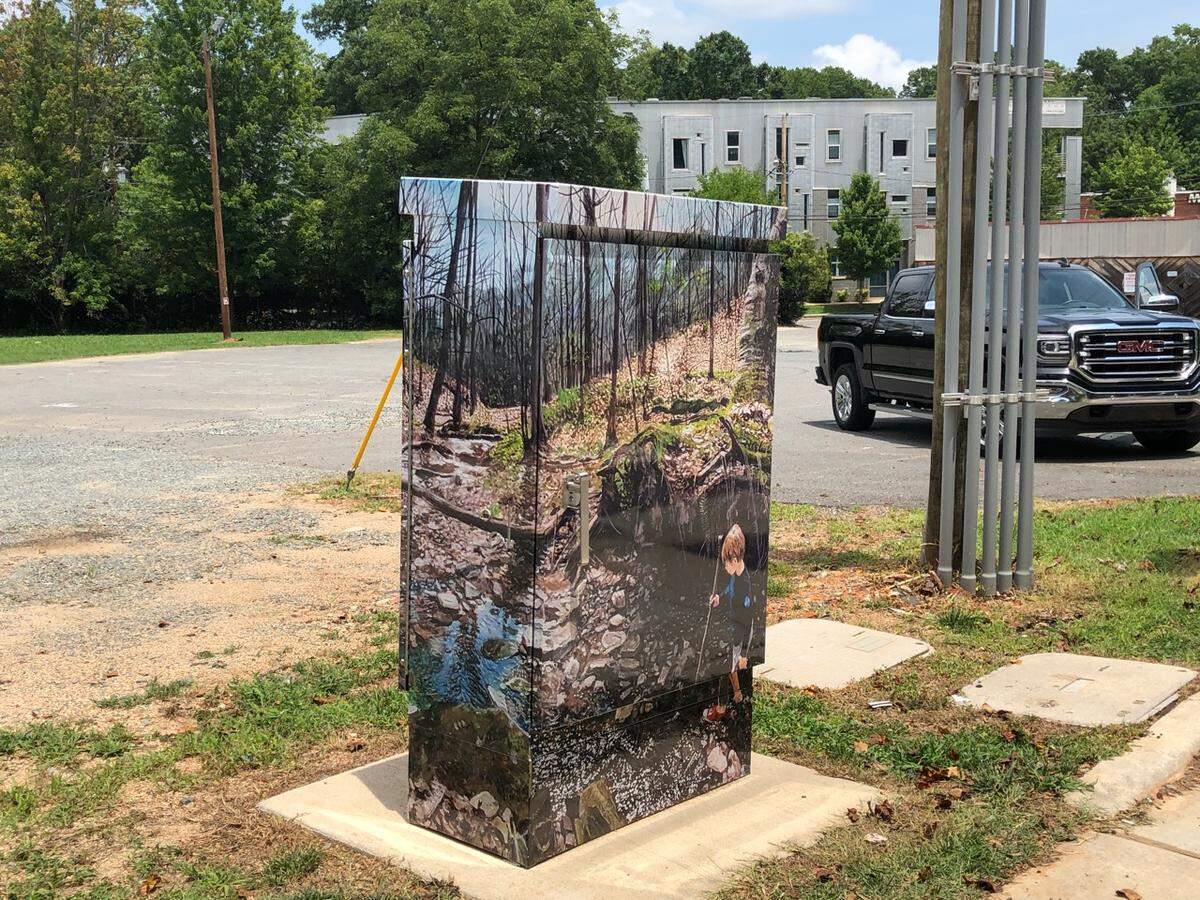 Artist David French’s “Deep Roots, Little Creek” shows his son playing in a wooded spot where he too used to explore as a kid. It can be found on Central Avenue across from Veterans Park.