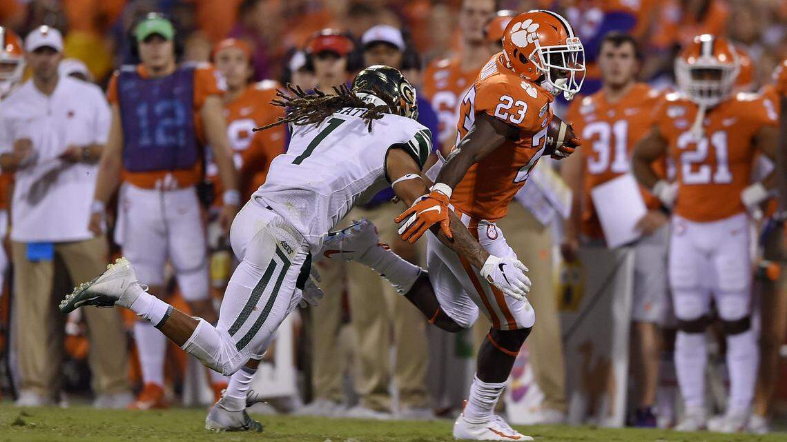 Clemson’s Lyn-J Dixon (23) rushes while being defended by Charlotte’s Jacione Fugate.