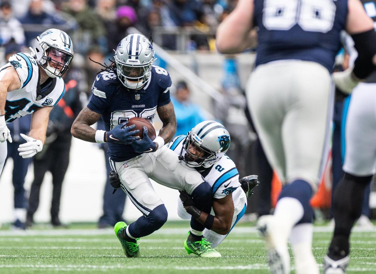 Dallas Cowboys wide receiver CeeDee Lamb, left, is tackled by Carolina Panthers cornerback Michael Jackson at the Bank of America Stadium in Charlotte, N.C., on Sunday, December 15, 2024.