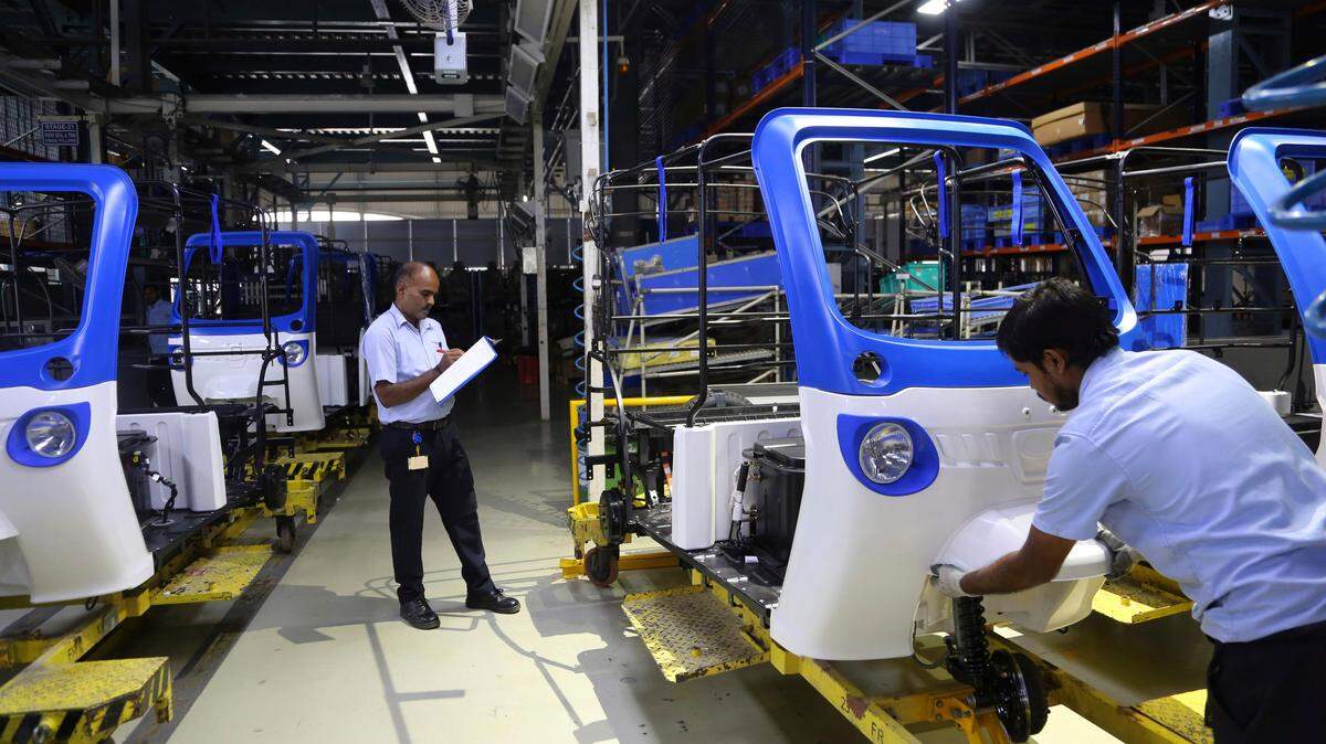 Indian workers perform a check on three-wheeler electric vehicles at an assembly line of Mahindra Electric facility in the outskirts of Bangalore, India, Thursday, Nov. 15, 2018. Mahindra Electric, a part of the US$ 20.7 billion Mahindra Group, inaugurated the company’s new Electric Technology Manufacturing Hub on Thursday. (AP Photo/Aijaz Rahi)
