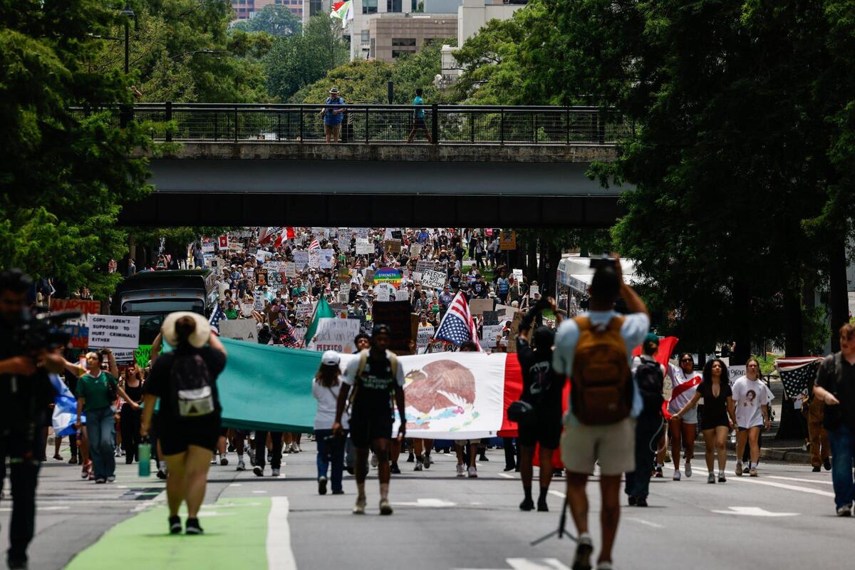 Protesters march along 4th Street during the No Kings protest that began earlier in the day at Foirst Ward Park in Charlotte Saturday, June 14, 2025.