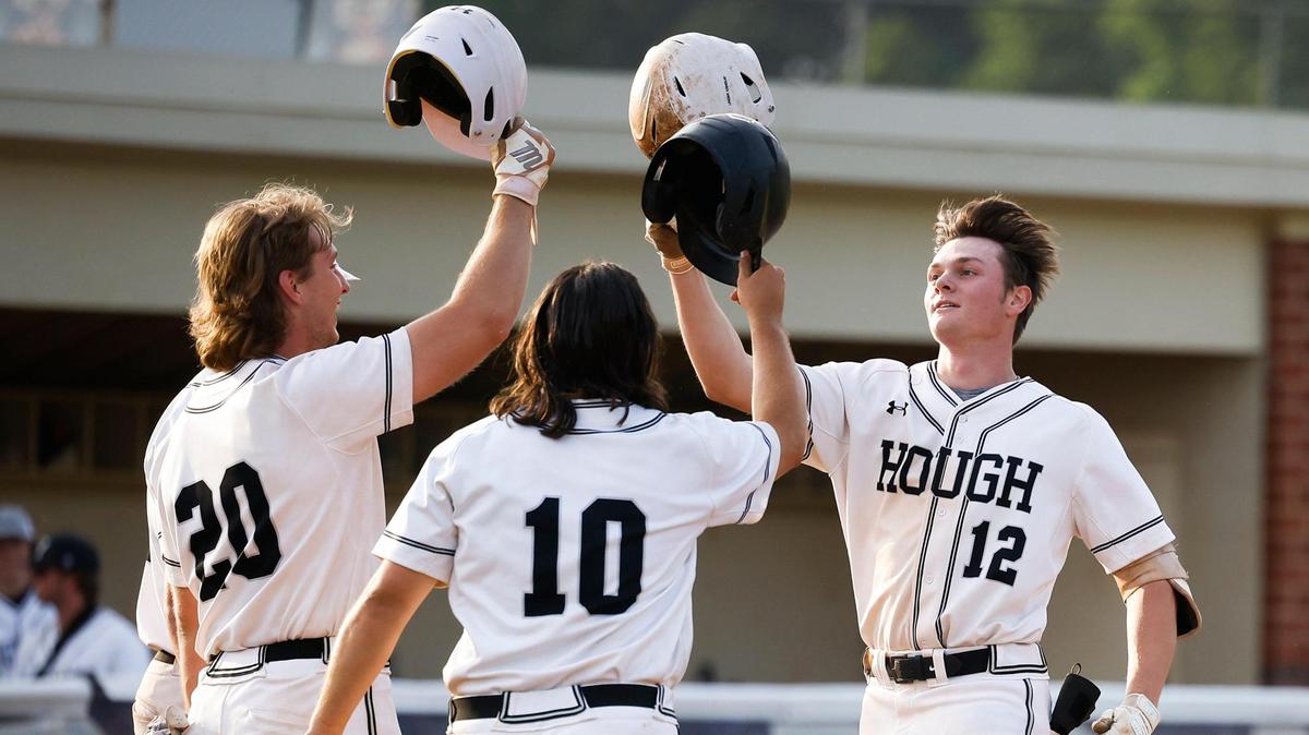 Hough’s Brock Donnelly (20) Hough’s Jake Gorman (10) and Hough’s Luke Holland (12) celebrate after Holland scored a run during the Queen City 3A/4A championship game against Hopewell at Hopewell High School in Huntersville, N.C., Thursday, May 5, 2022. Hough beat Hopewell 5-4.