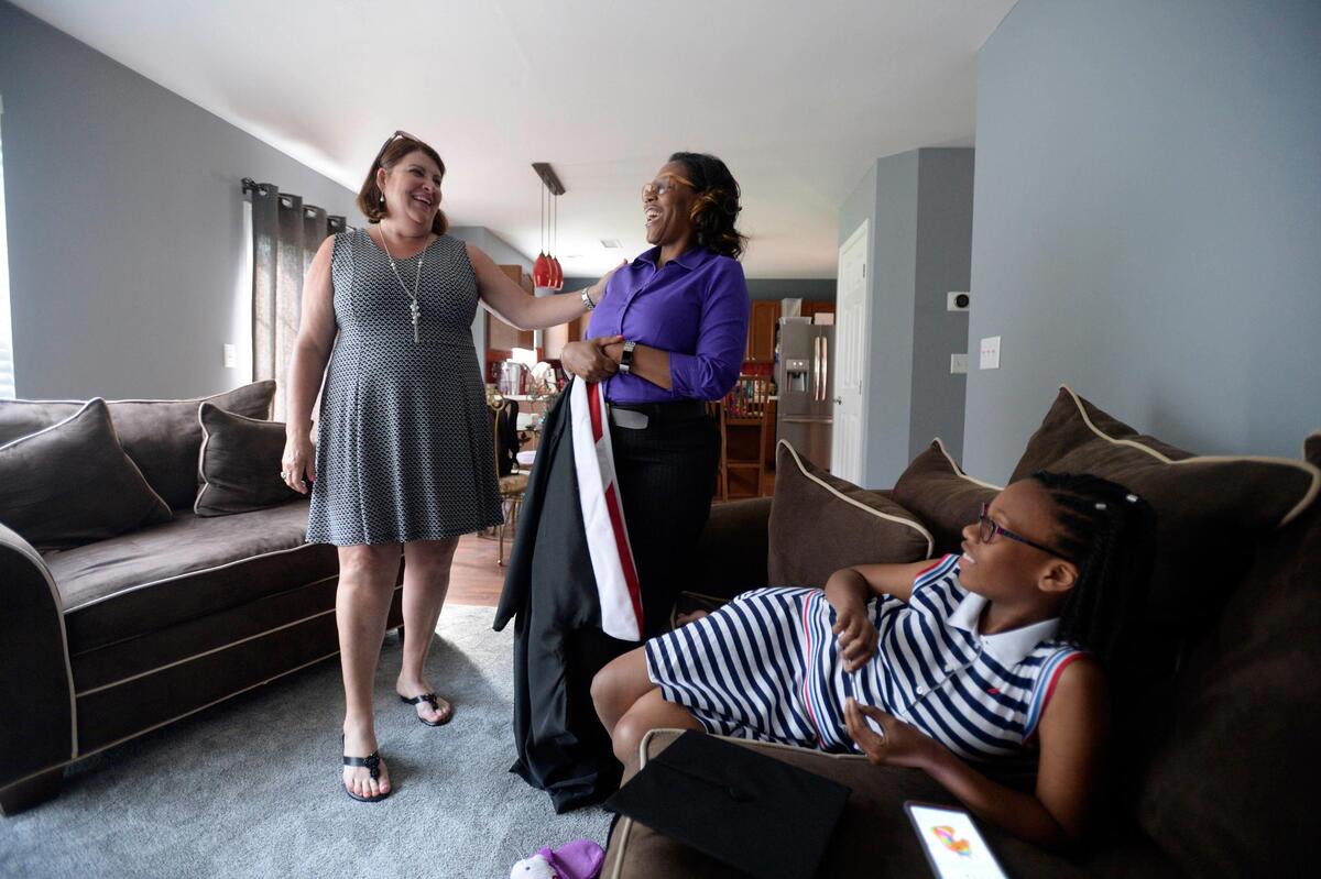 LaWanda Walker, center, shares a laugh with Martha Honeycutt, left, of the ANSWER Scholarship organization, and Walker’s 10-year-old daughter, Alexandria. LaWanda Walker is a single mom who had a rough start earlier in life and is earning her bachelor’s degree this spring from Belmont Abbey College.