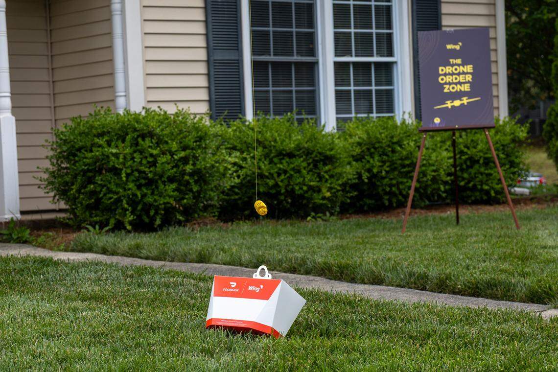 A Wing delivery drone drops off a DoorDash delivery container in the lawn of a Charlotte home on Wednesday, May 14, 2025.