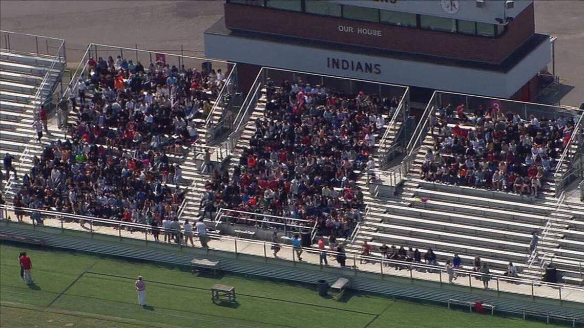 In this photo taken from WSOC’s helicopter, Arndt Middle School students sit in a football stadium while authorities investigated a possible threat on Wednesday, May 4, 2022.