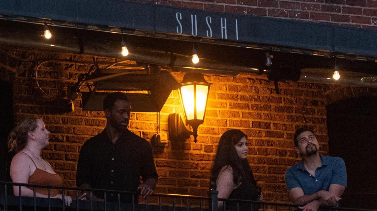 Patrons enjoy food and drinks on the second-floor exterior bar of Soul Gastrolounge in Plaza Midwood Monday evening, Aug. 8, 2022 in Charlotte, N.C.