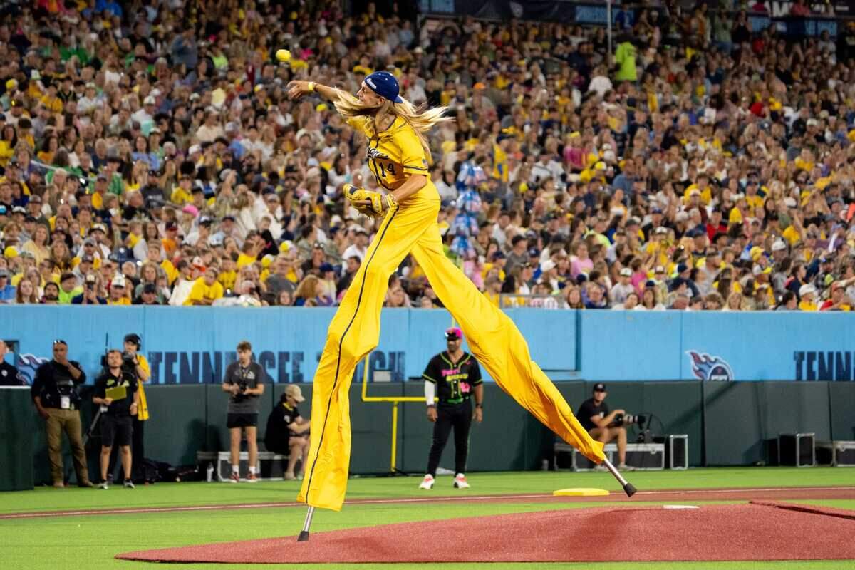 Savannah Bananas player Dakota Albritton (14) pitches during the sixth inning of a mid-May game against the Party Animals at Nissan Stadium in Nashville.