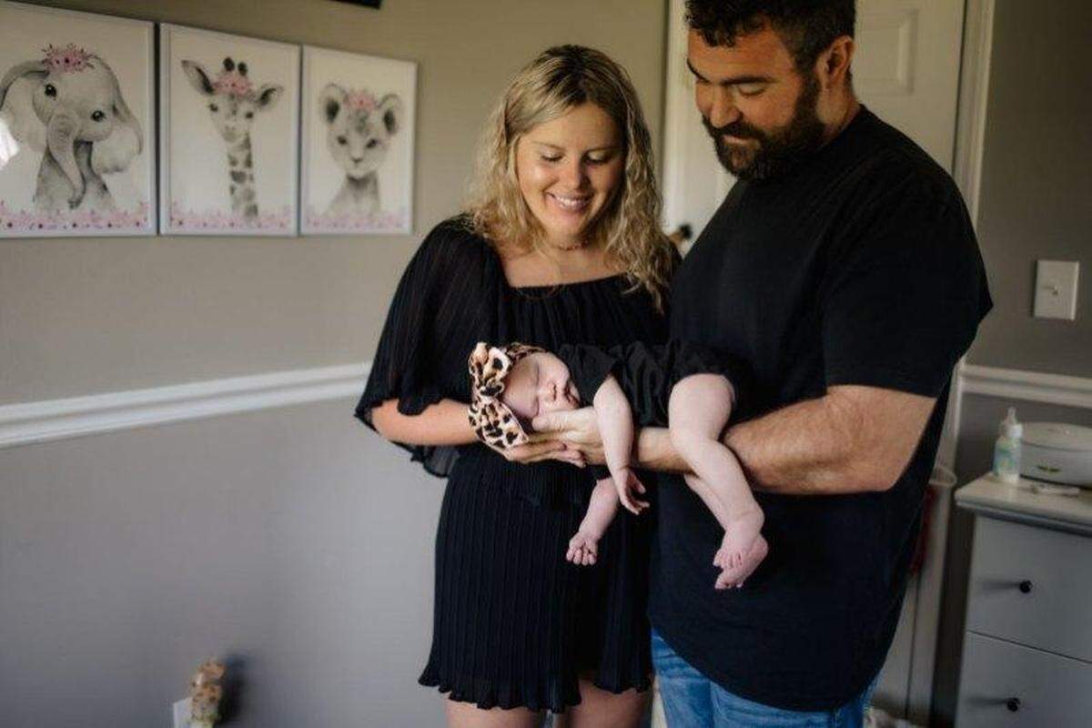 Dillon and Casey Sutton cradle their daughter Zoie in her room at their home in Crouse.