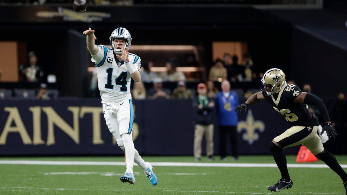 Carolina Panthers quarterback Sam Darnold (14) passes under pressure from New Orleans Saints outside linebacker Demario Davis (56) in the first half of an NFL football game in New Orleans, Sunday, Jan. 2, 2022.