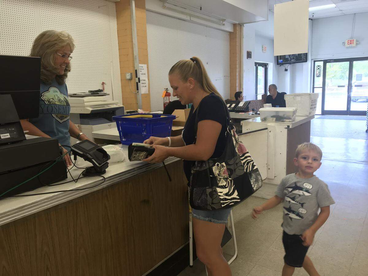 Jennifer Swindell (center) pays Cathy Vanderford for her purchases as her son Josiah watches on Wednesday. Swindell, of Dallas, has been an avid sewer since she was a teen and grew up going to Mary Jo’s.