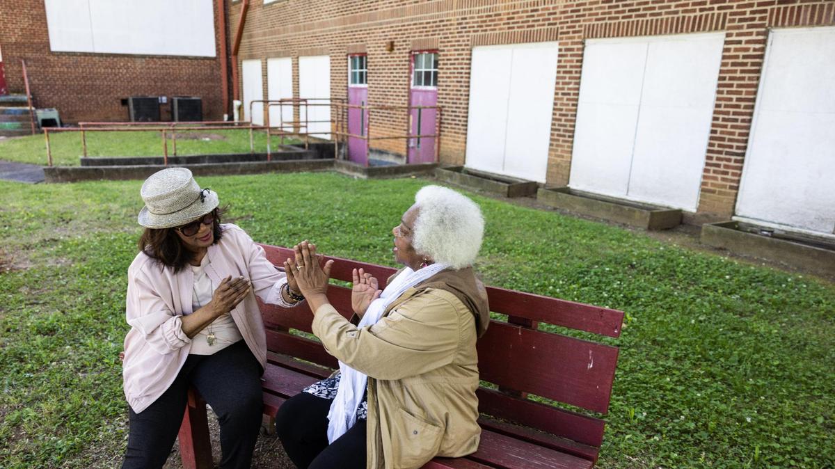 Berlinda Tolbert, left, and Mary Brown reminisce on their childhood by playing “Patty Cake” and “Miss Mary Mack” outside of the former Morgan Elementary School in Charlotte, N.C., on Thursday, May 4, 2023. Berlinda Tolbert and Mary Brown are longtime friends who met at the now closed Morgan School.