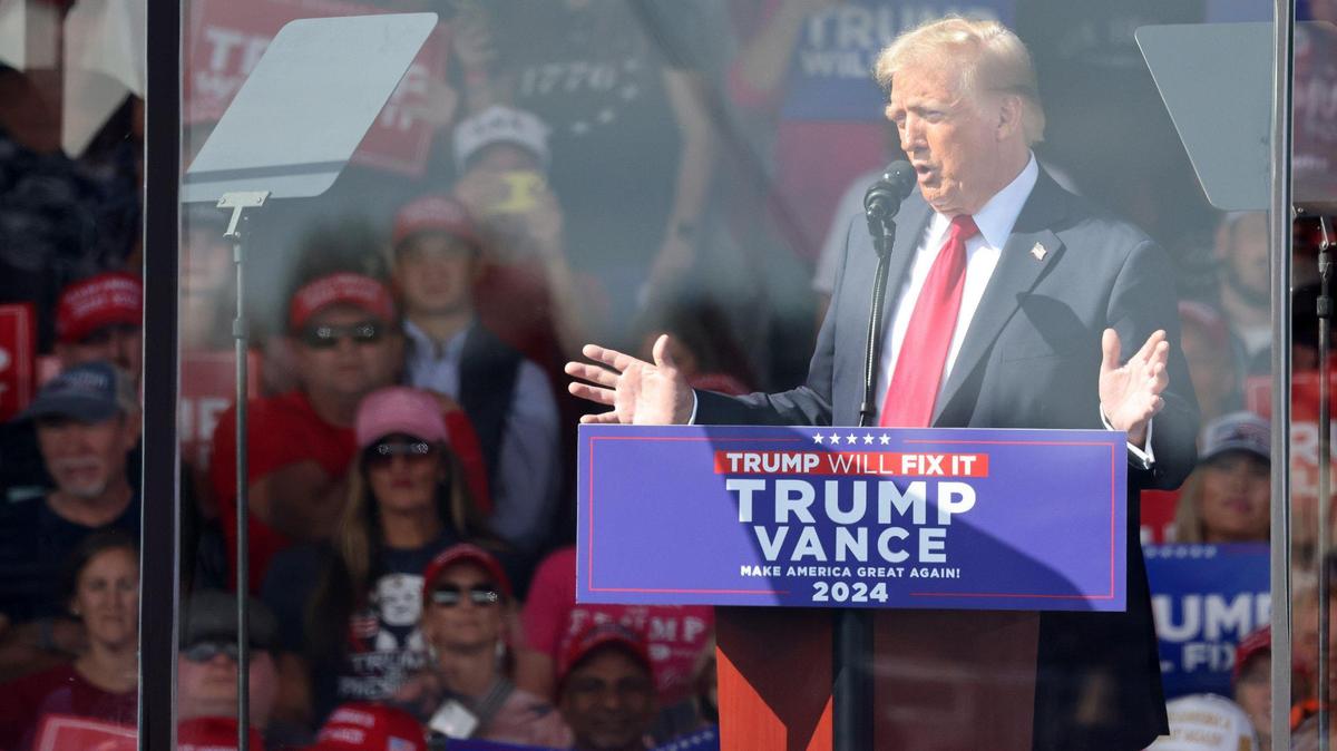 In the final days of campaigning, Donald Trump stands behind a barrier Saturday, Nov. 2, 2024 at a rally in Gastonia, N.C. Do bankers want him to win?