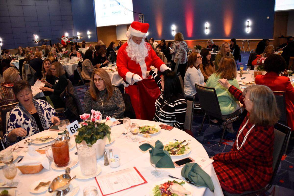 Santa Claus makes his away around tables to collect donations during the Good Friends holiday luncheon at Charlotte Convention Center on Thursday, Dec. 9, 2021.