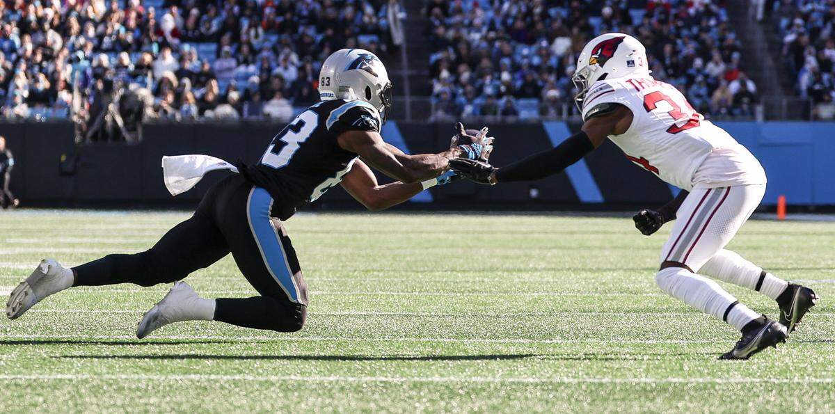 Panthers wide receiver David Moore, left, extends for a catch as Cardinals safety Jalen Thompson defends during the game at Bank of America Stadium in Charlotte, NC on Sunday, December 22, 2024.