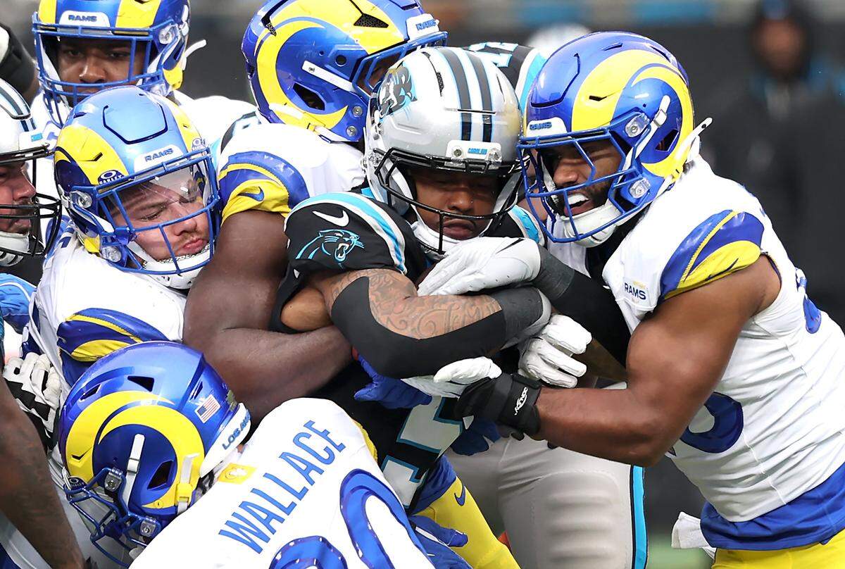 Panthers RB Rico Dowdle, center, battled against the formidable LA Rams defense, striving to gain crucial yards during action on Nov. 30, 2025, at Bank of America Stadium in Charlotte. The Panthers defeated the Rams 31-28.