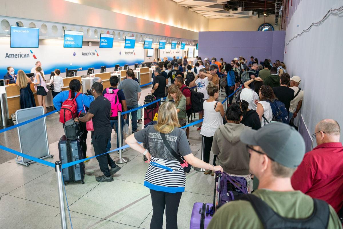 Passengers line up at the American Airlines check-in desk inside the Charlotte Douglas International Airport on August 5, 2024. The airport is facing many delays and cancellations due to Hurricane Debby’s landfall in Florida.