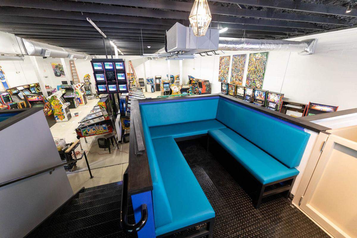 A booth on the upper level of Super Abari overlooks the main game room. The art on the right wall is by Charlotte artist John Hairston Jr.