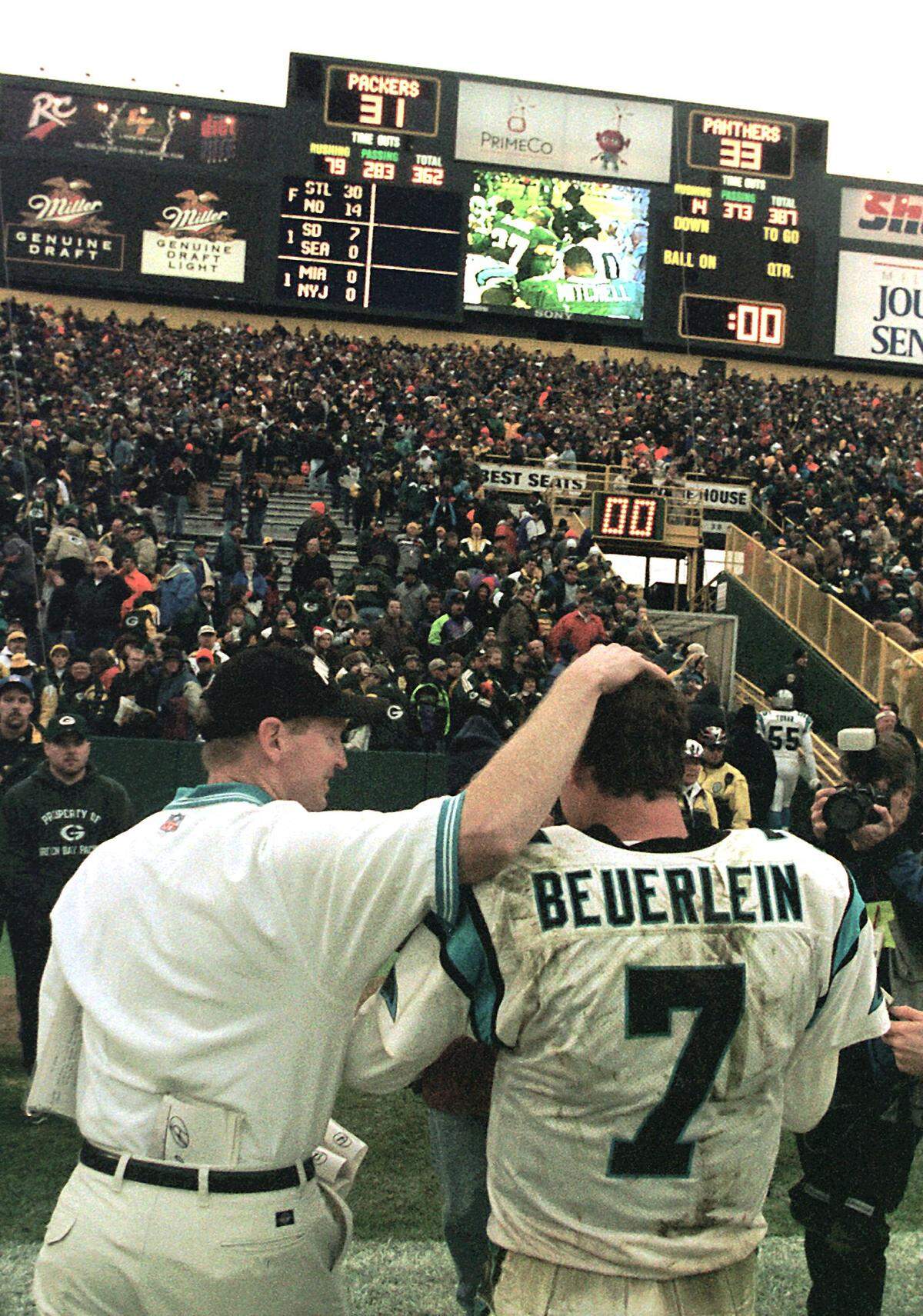Panthers quarterback Steve Beuerlein (7) is congratulated by a team staff member in 1999 as he leaves Lambeau Field after scoring on a draw play to edge Green Bay, 33-31.