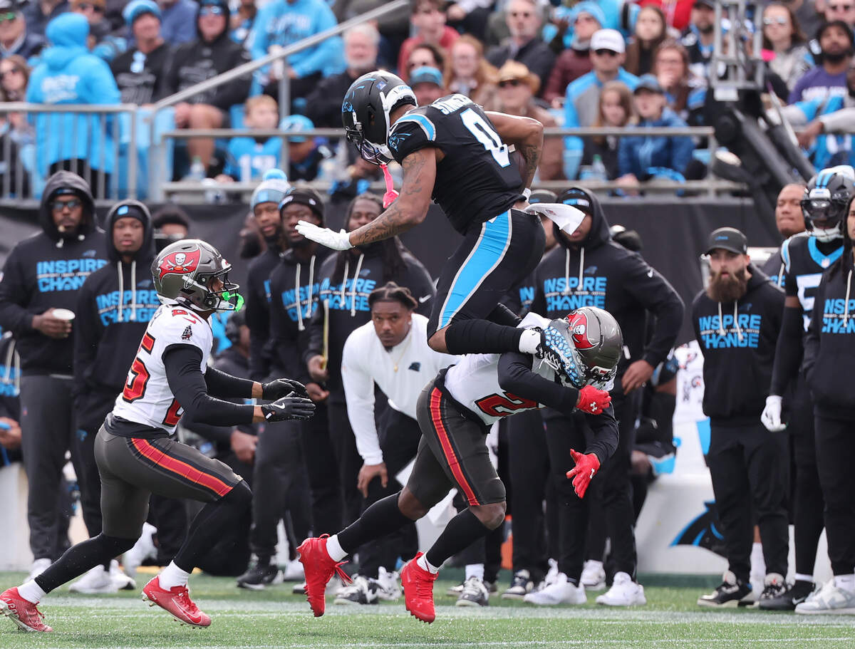 Carolina’s Ja'Tavion Sanders leaps over Tampa Bay’s Benjamin Morrison on Sunday at Bank of America Stadium in Charlotte.