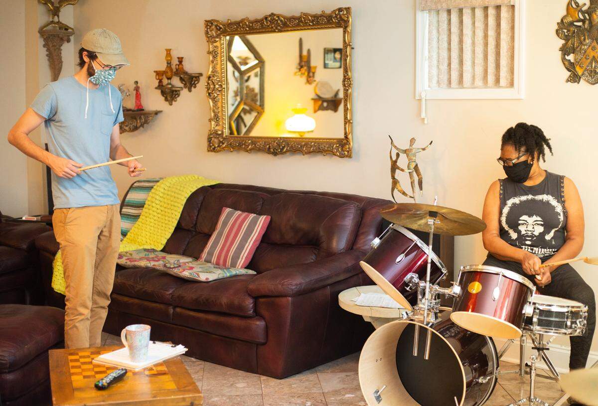 Ryan Colebeck, left, instructs retiree Alvesta Cody during a drum lesson in the den at Cody’s home. Cody, 70 had an ulterior motive for choosing the drums. She saw it as an opportunity to build confidence and help with her memory and physical coordination. 