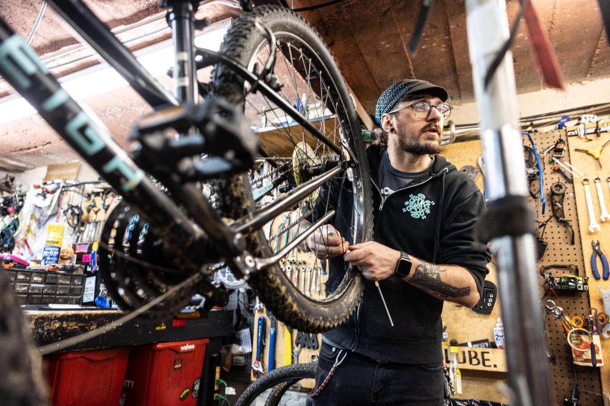Brandon Grant works on a bike at Trips for Kids Charlotte.