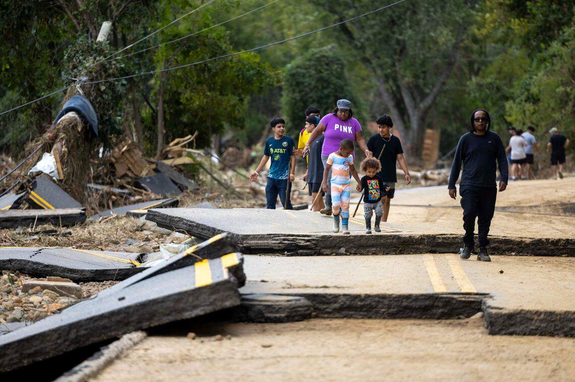 Swannanoa residents walk through devastating flood damage from the Swannanoa River on Sunday, Sept. 29, 2024. The remnants of Hurricane Helene caused widespread flooding, downed trees, and power outages in western North Carolina.