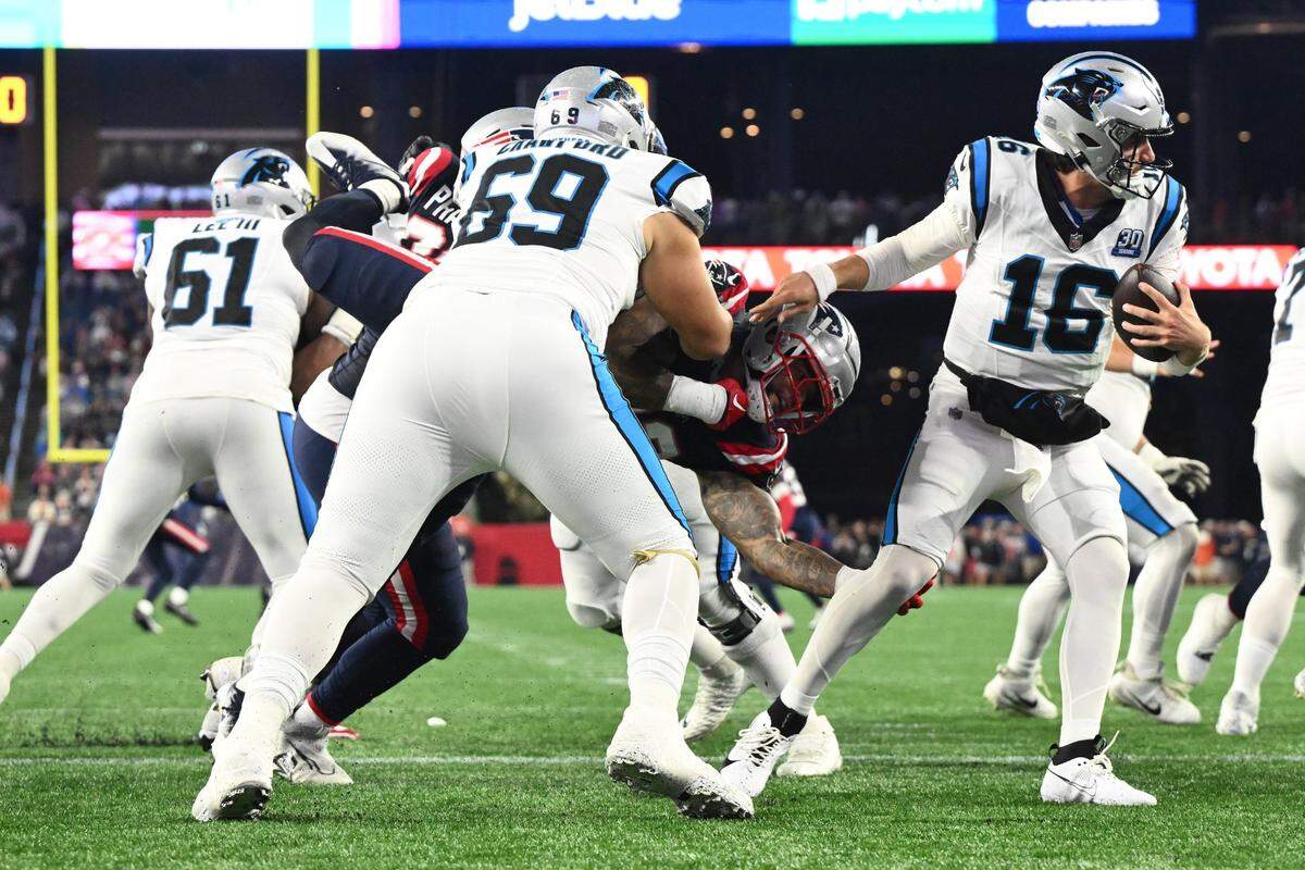 Aug 8, 2024; Foxborough, Massachusetts, USA;  Carolina Panthers quarterback Jack Plummer (16) escapes a tackle from New England Patriots linebacker Oshane Ximines (93) during the first half at Gillette Stadium. Mandatory Credit: Brian Fluharty-USA TODAY Sports