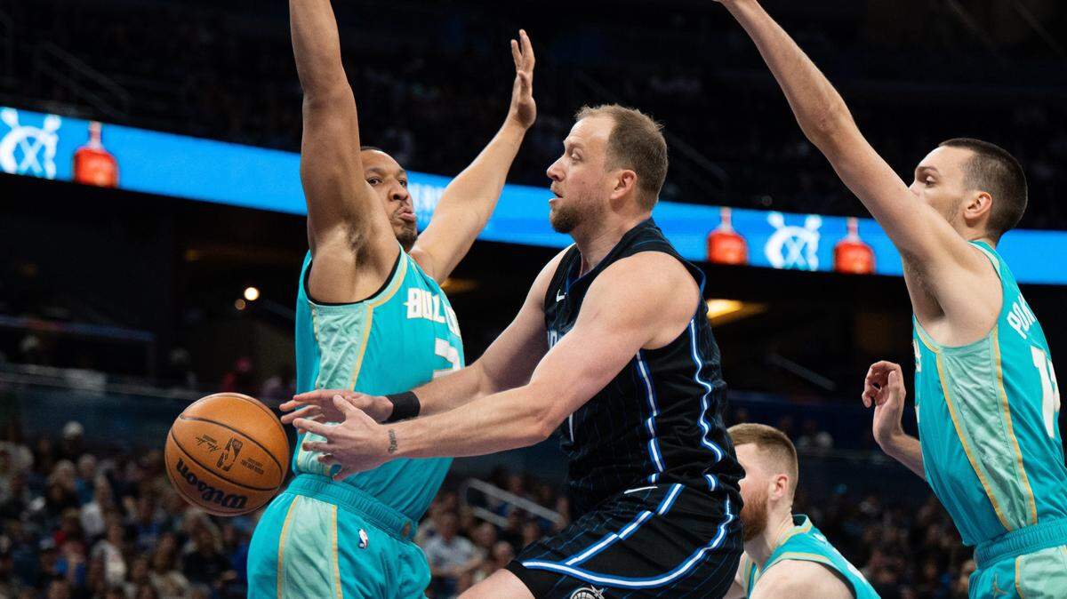 Mar 19, 2024; Orlando, Florida, USA; Orlando Magic forward Joe Ingles (7) passes the ball around Charlotte Hornets forward Grant Williams (2) in the second quarter at KIA Center. Mandatory Credit: Jeremy Reper-USA TODAY Sports