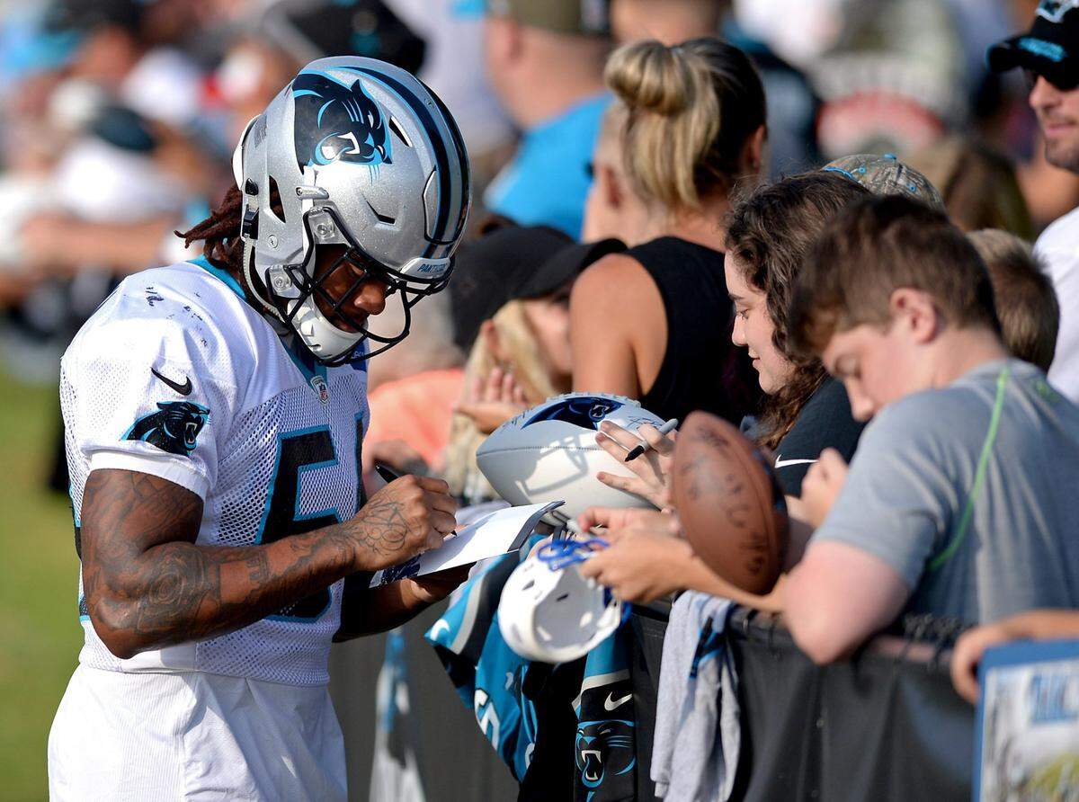 Carolina Panthers linebacker Shaq Thompson, left, stops to sign autographs for fans prior to practice on Monday, August 13, 2018 at Wofford College in Spartanburg, SC.