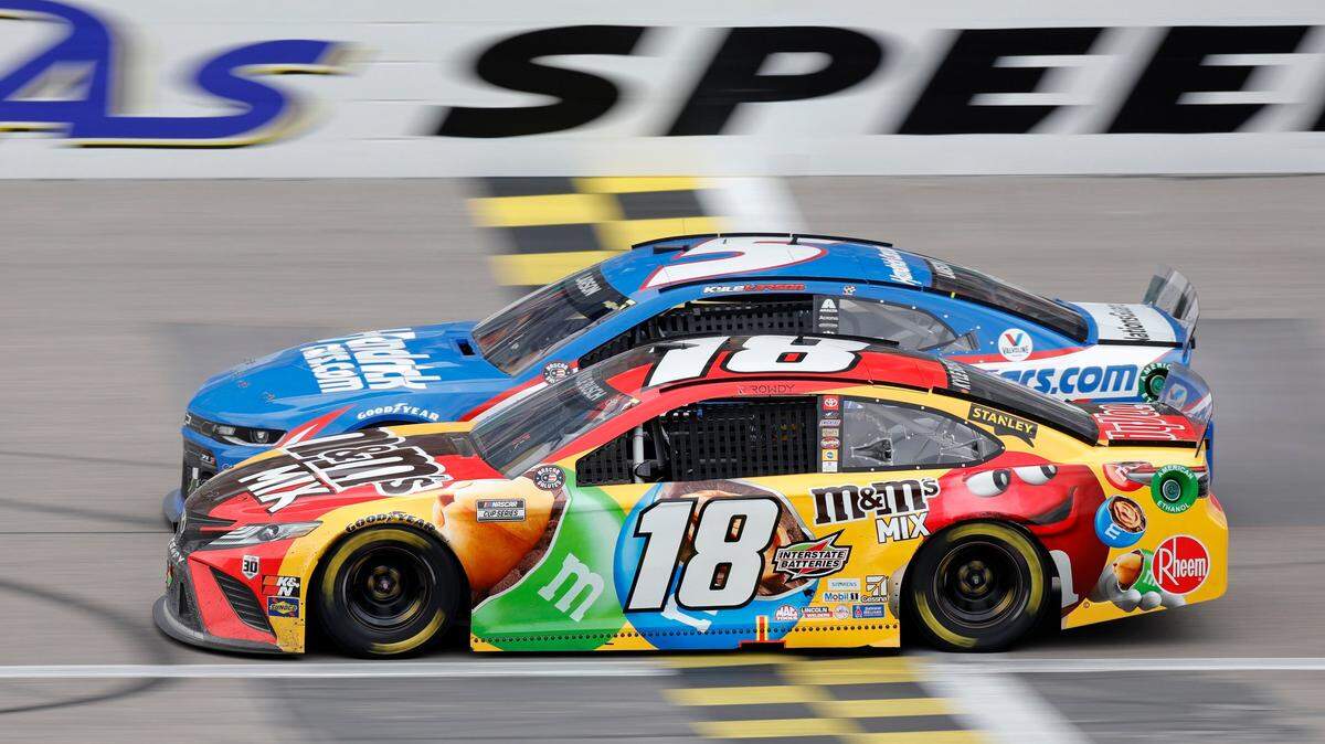 Kyle Larson (5) and Kyle Busch (18) battle for the lead in the final laps of a NASCAR Cup Series auto race at Kansas Speedway in Kansas City, Kan., Sunday, May 2, 2021. (AP Photo/Colin E. Braley)