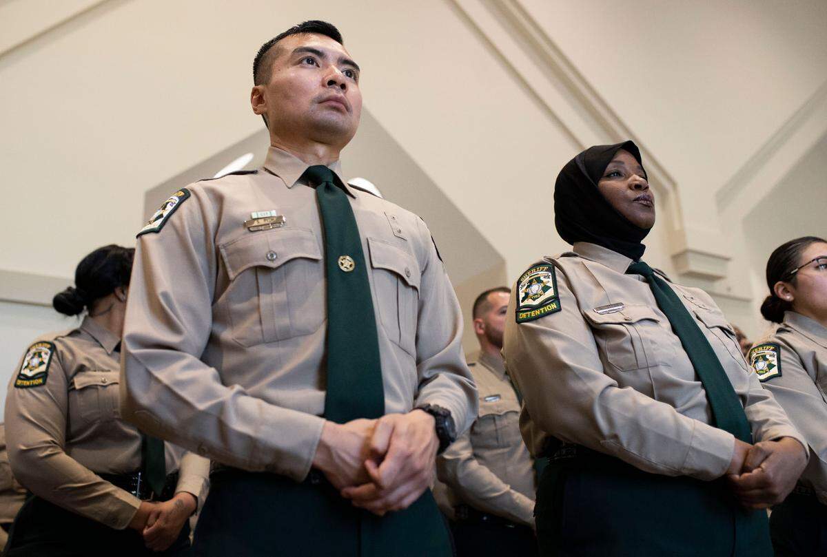 Steve Pich and Dana Todman stand with their platoon before entering the sanctuary of Calvary Baptist Church to graduate from the Mecklenburg County Detention Officer Certification Course on Monday, June 8, 2023.