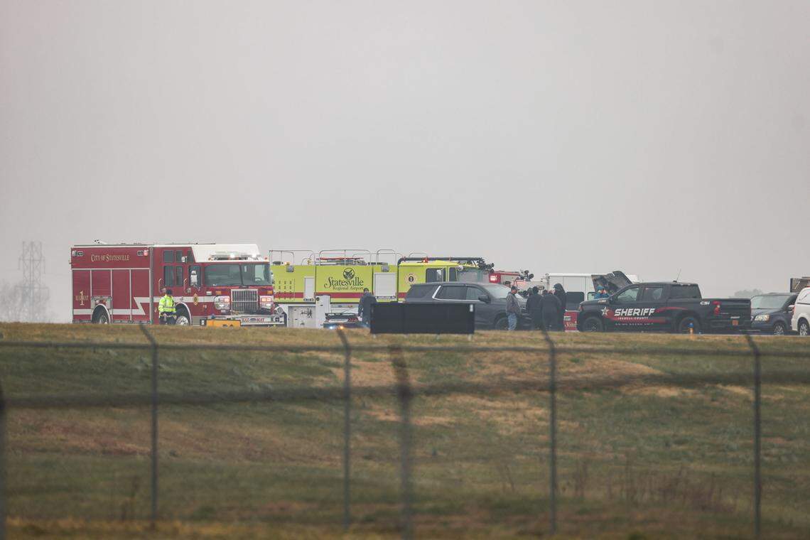 Statesville officials gather at the site where a plane owned by NASCAR driver Greg Biffle crashed while landing at Statesville Regional Airport on Thursday morning, according to officials.