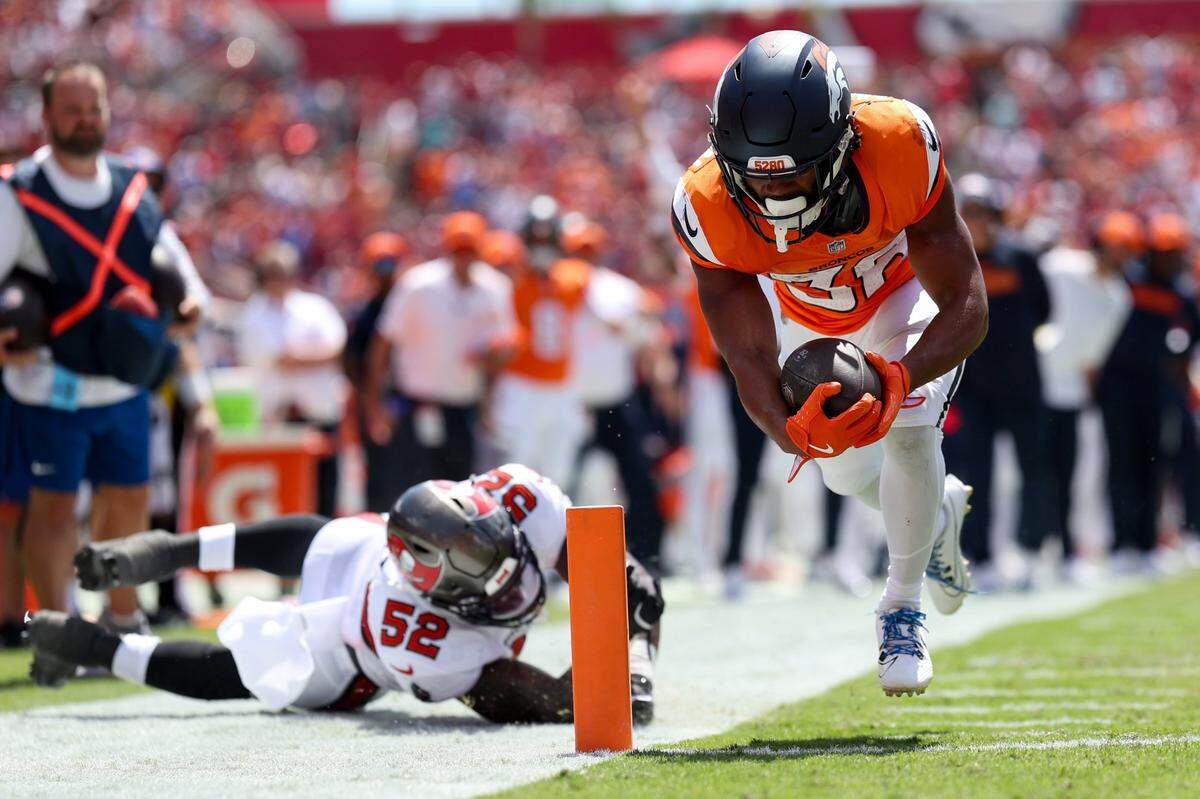 Sep 22, 2024; Tampa, Florida, USA; Denver Broncos running back Jaleel McLaughlin (38) scores a touchdown against the Tampa Bay Buccaneers in the first quarter at Raymond James Stadium. Mandatory Credit: Nathan Ray Seebeck-Imagn Images