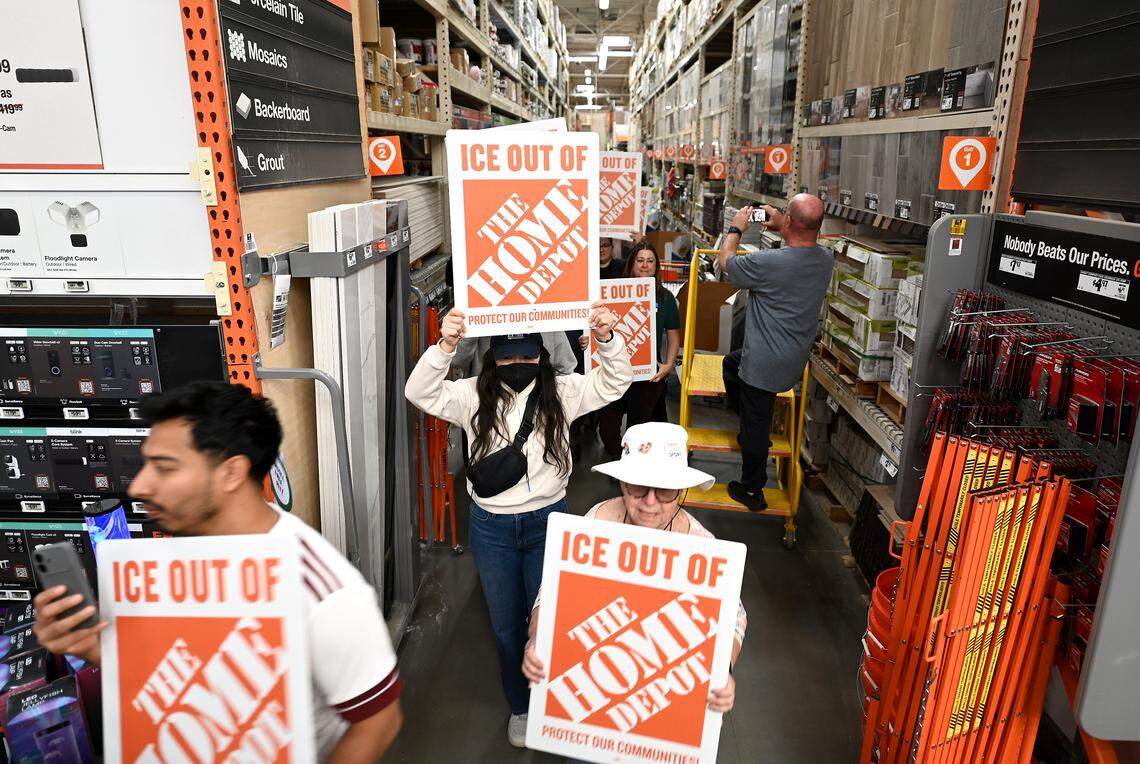 Protesters walk down an aisle at the Home Depot on North Wendover Road in Charlotte, NC on Wednesday, November 19, 2025. 