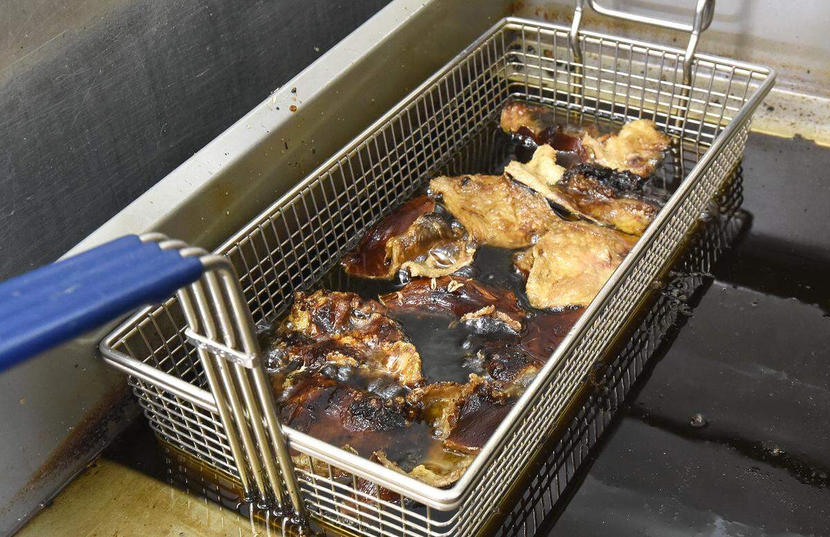 After frying pork skins all week, Lewis Donald uses the pork-enriched oil to fry chicken on Sundays.