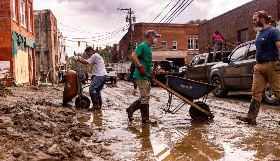 Residents and volunteers clean up on Tuesday, Oct. 1, 2024 after the French Broad River flooded downtown Marshall. The remnants of Hurricane Helene caused widespread flooding, downed trees, and power outages in western North Carolina.