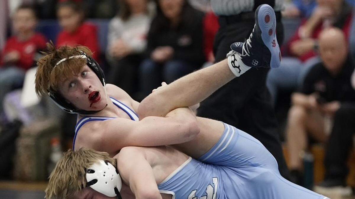 Sporting a bloody lip, Charlotte Christian's Harrison Landon, top, gets a leg hold on Charlotte Latin's Davis Jones (who has a bloody nose) during their 132-pound championship match Saturday at the N.C. Independent Schools Athletic Association's state championships in Charlotte.
