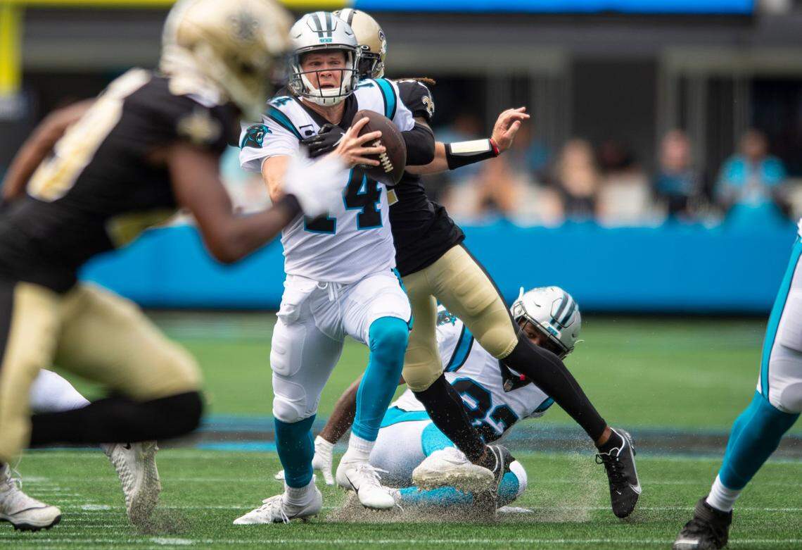 Panthers quarterback Sam Darnold, center, tries to evade the grasp of Saints cornerback Bradley Roby at Bank of America Stadium on Sunday, September 19, 2021 in Charlotte, NC. The Panthers defeated the Saints 26-7.