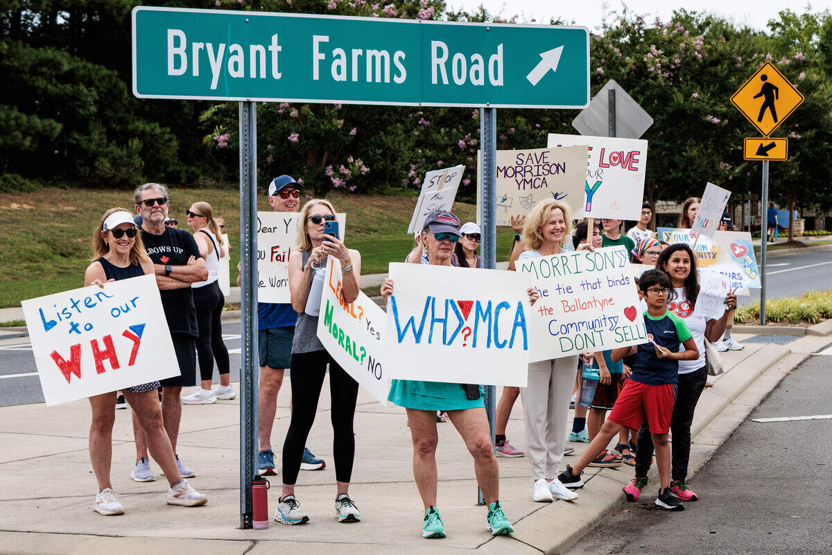 Several protesters stand inside the nearby roundabout during the Morrison Family YMCA protest in Ballantyne on Sunday, July 12, 2026.