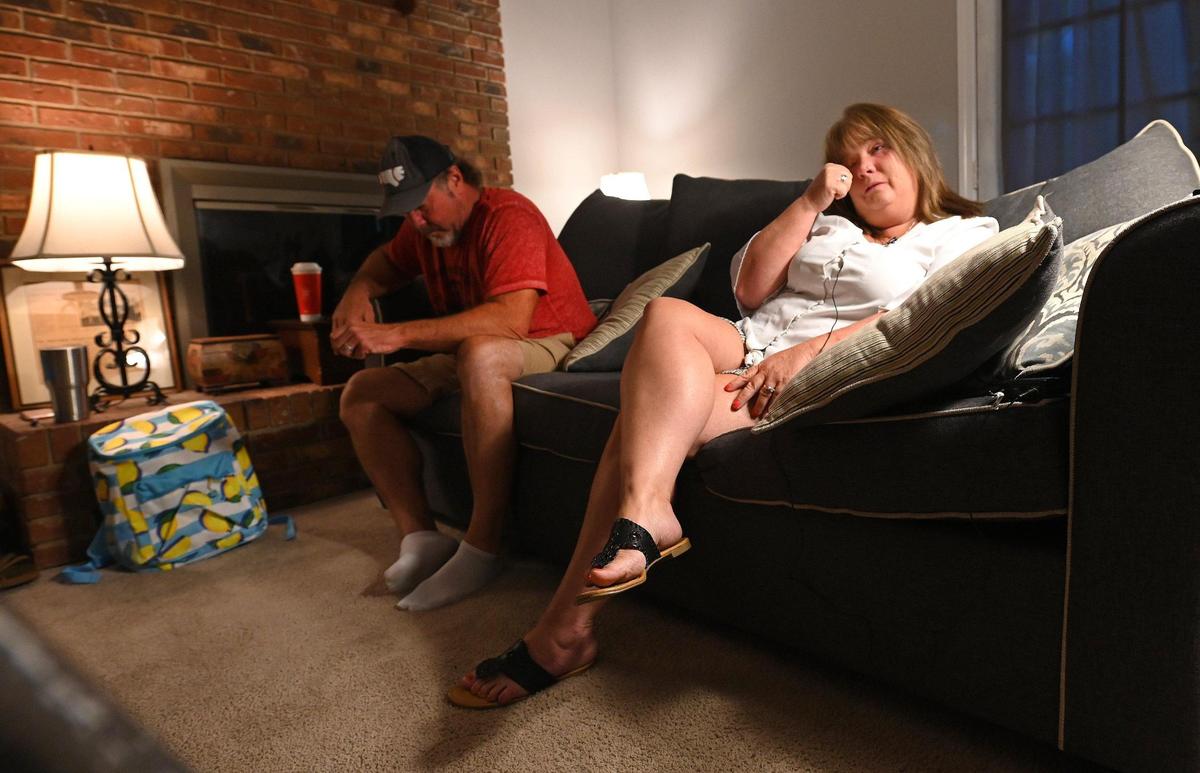 Shelley Allen, right, wipes away a tear as her husband, Scott, left, listens to her story. Allen is a 50-year-old woman who has gone almost totally blind over the past year due to a rear and peculiar ailment that doctors think may have been brought on by her getting COVID within a week of getting a hysterectomy.