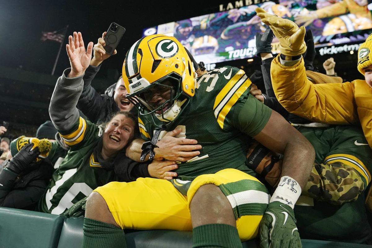 Emanuel Wilson of the Green Bay Packers celebrates with fans after his rushing touchdown against the New Orleans Saints during the fourth quarter at Lambeau Field on December 23, 2024 in Green Bay, Wisconsin. 