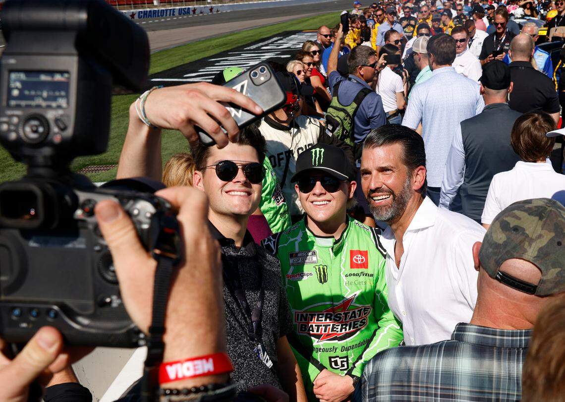 Donald Trump Jr., right, stops and poses for photos with people on pit road at Charlotte Motor Speedway prior to the running of the Bank of America Roval 400 on Sunday, October 13, 2024 in Concord, NC.