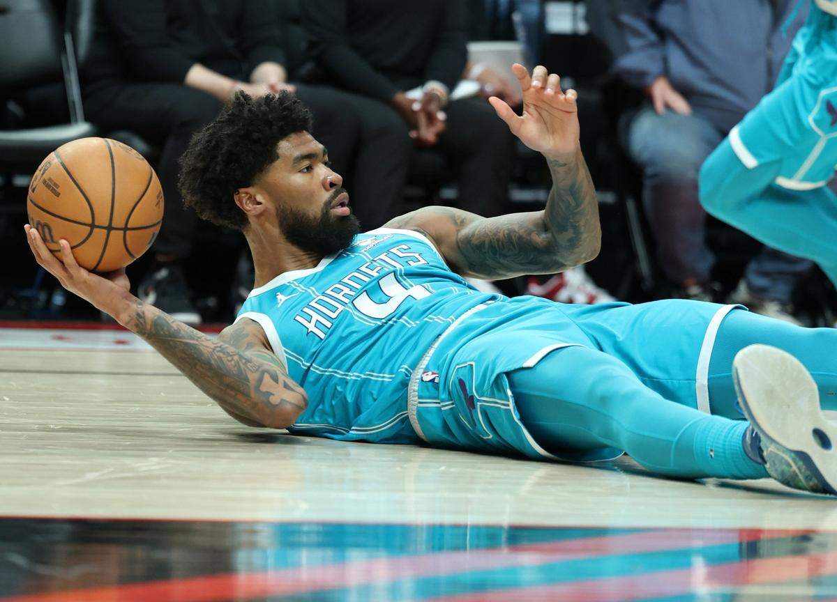 Feb 25, 2024; Portland, Oregon, USA; Charlotte Hornets center Nick Richards (4) looks to pass the ball from the floor against the Portland Trail Blazers in the first quarter at Moda Center. Mandatory Credit: Jaime Valdez-USA TODAY Sports