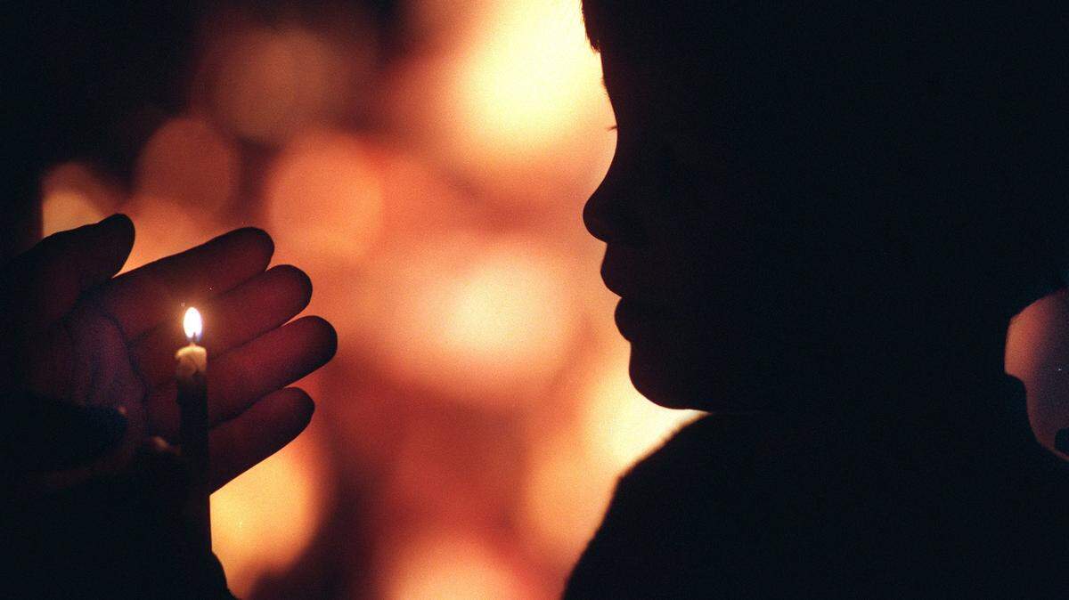 12/13/98 Seven year old Dalton Reese (cq) of McAdenville gets a light from his father for his candle at the Schiele Museum’s Cololnial Christmas celebration in Gastonia. Carolers held candles and gathered around the bonfire to experience an 18th centurystyle Christmas.