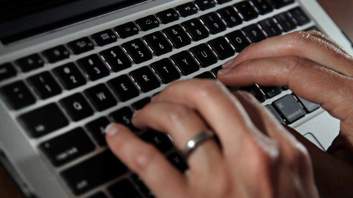 FILE- In this June 19, 2017, file photo, a person types on a laptop keyboard in North Andover, Mass. (AP Photo/Elise Amendola, File)