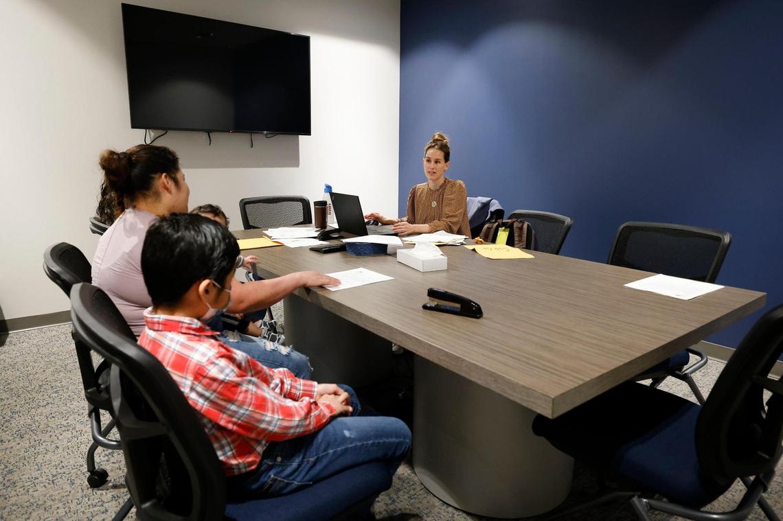 Staff attorney Rebekah Niblock, of Charlotte, N.C., speaks with a family seeking asylum at the Charlotte Center for Legal Advocacy in Charlotte, Saturday, March 26, 2022.