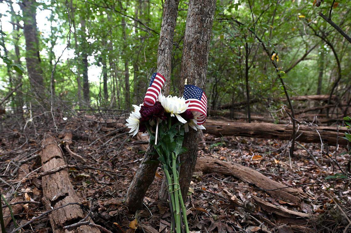 The small bouquet of flowers and flags left in the woods behind Rod of God by Louie Pinheiro as a makeshift memorial to his brother John, who died in the crash of Eastern Flight 212.