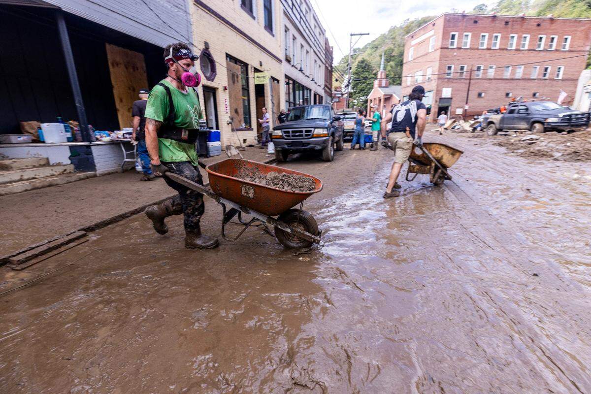 Western North Carolina residents are dealing with massive amounts of mud in Hurricane Helen’s aftermath. Shown, residents and volunteers on Tuesday, Oct. 1, 2024 after the French Broad River flooded downtown Marshall.
