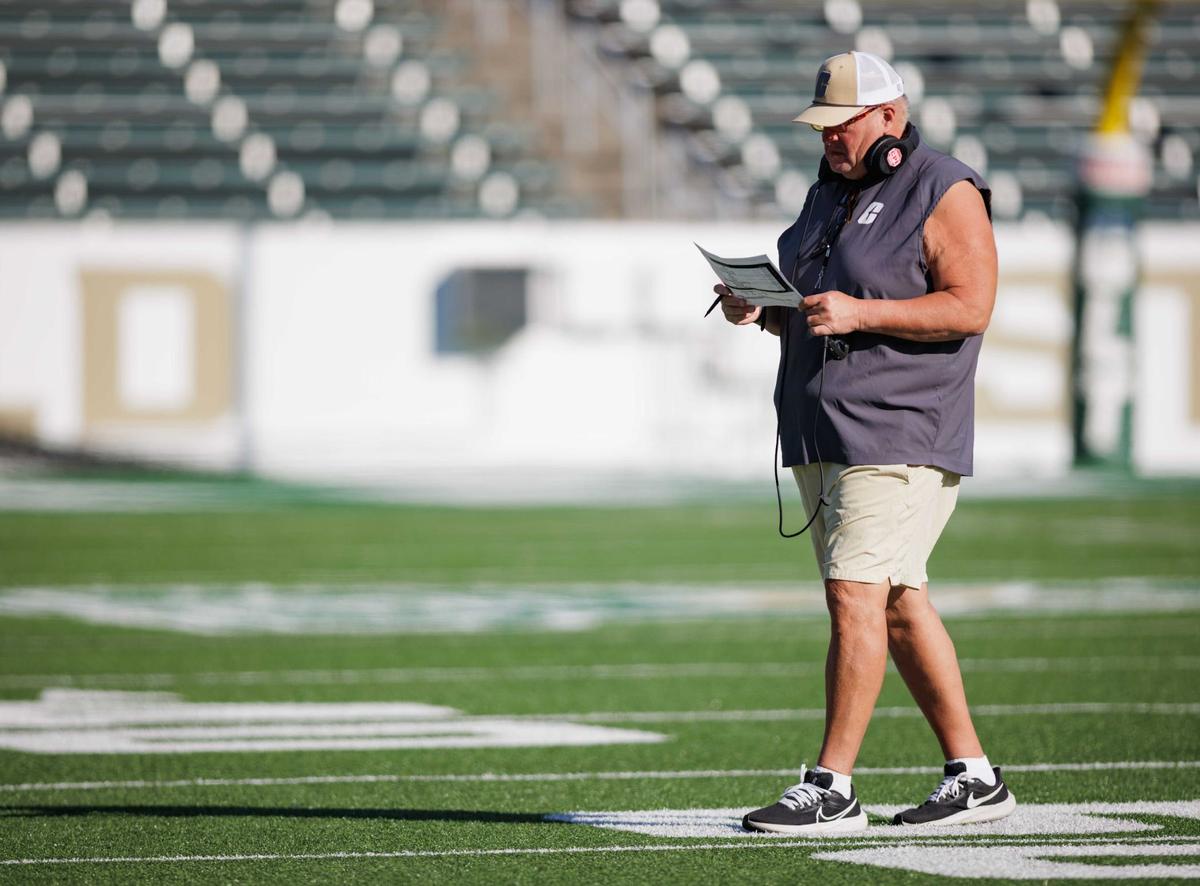 Charlotte 49ers’ head coach Biff Poggi reviews his scrimmage agenda during the final intrasquad game at Jerry Richardson Stadium Saturday August 24, 2024.